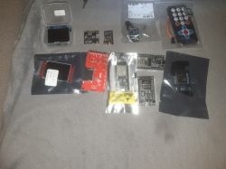 Set of ESP32 modules, displays, encoders, and IR remote control on fabric