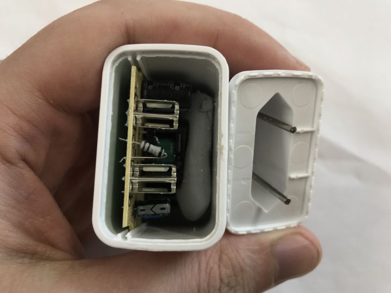Disassembled USB-C charger showing internal PCB and loose power plug