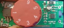 Close-up of a PCB with a red rotary dial and labeled electronic components