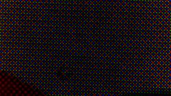 Przybliżony widok pikseli w kolorach czerwonym, zielonym i niebieskim, rozmieszczonych w regularnym wzorze na powierzchni procesora.