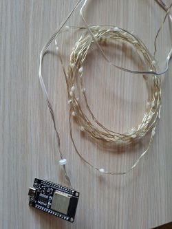 ESP32 module connected to LED strip wires.