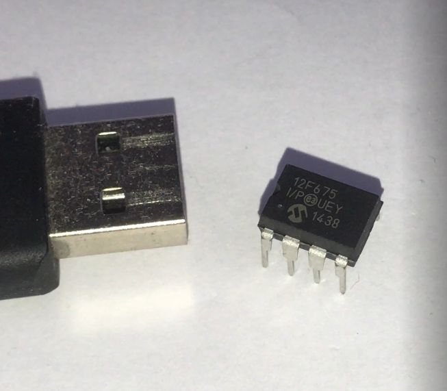 USB connector next to a PIC12F675 DIP8 microcontroller on a white background