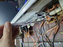 Osoba sprawdzająca obwody elektroniczne przy użyciu próbówki w urządzeniu.