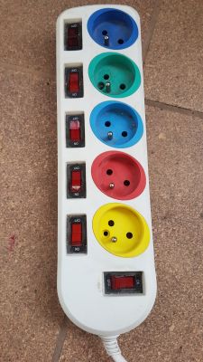 Uszkodzona listwa z podświetlanymi przełącznikami i kolorowymi gniazdami.