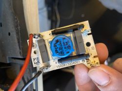 Osoba trzyma uszkodzony element elektroniczny z ekspresu do kawy.