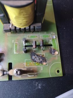 Spalony fragment płytki PCB z widocznymi uszkodzeniami elementów elektronicznych