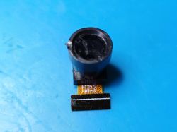 Camera Module with FFC Ribbon H12577 A9 B Miniature camera module with FFC ribbon cable on blue background, marked H12577 A9 B on the cable.