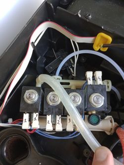 Wnętrze ekspresu do kawy z widocznymi czterema oznaczonymi elektrozaworami