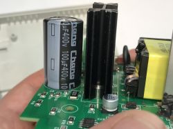 Close-up of a circuit board with electronic components, including capacitors and a heatsink.