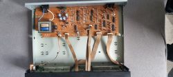 Wnętrze urządzenia elektronicznego z widoczną płytą główną i taśmami połączeniowymi