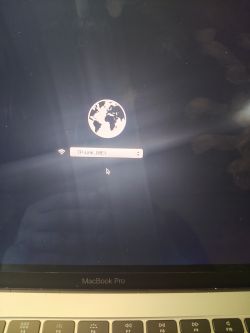 Ekran MacBooka Pro z ikoną obracającego się globusa i dostępnej sieci Wi-Fi TP-Link_08E1.