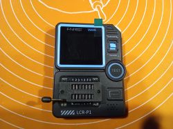 Tester elektroniczny LCR-P1 na pomarańczowej macie z widocznym ekranem i gniazdem ZIF