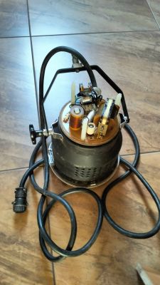 Lampa elektryczna z przewodami i otwartą obudową na płytkach ceramicznych.
