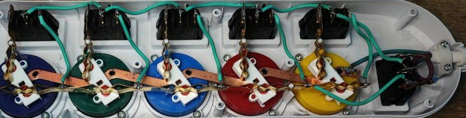 Interior of a power strip with visible colorful sockets and wiring.