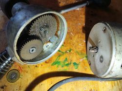 Gears of Celma PRCb Drill Open gear housing of a Celma PRCb drill on a wooden surface with a coin nearby.
