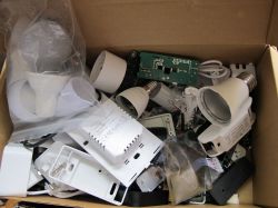 A box with various electronic components, such as LED bulbs, mounting brackets, and electronic circuits.