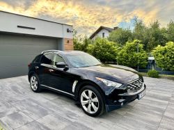 Black Infiniti SUV parked on a modern driveway in front of a contemporary house