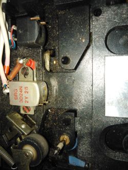 Wnętrze urządzenia z widocznymi komponentami elektrycznymi i kurzem.