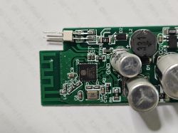 Close-up of a green printed circuit board with electronic components.