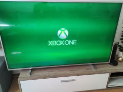 Telewizor Philips 58PUS7855 z zielonym ekranem i logo Xbox One, z widocznymi poziomymi pasami.