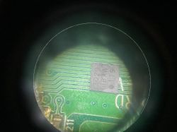 Układ scalony na zielonej płytce PCB widziany przez lupę, oznaczenie na układzie to 3020 88AW 119.
