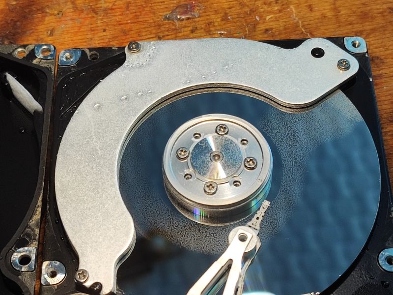 Inside a Flood-Damaged Hard Drive Inside of a hard drive with visible head and platter covered in moisture.
