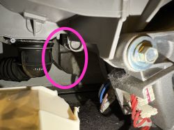 Wnętrze pralki Electrolux z elementem hydraulicznym oznaczonym różowym okręgiem.