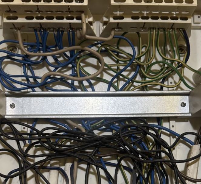 Plątanina przewodów w skrzynce elektrycznej z widocznymi zaciskami