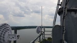 Radio Antenna Above the Lake View of radio antennas mounted on a pole above a lake.