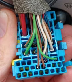 Close-up of a blue car radio wiring connector with multiple connected wires.