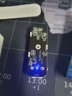 Close-up view of a circuit board with components, featuring a lit blue LED.