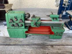 Model zielonej tokarki z czerwoną podstawą.