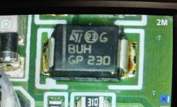 Zbliżenie elementu SMD na PCB z napisem „ST BUH GP 230” i oznaczeniem „2M”.