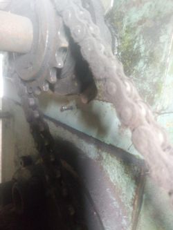 Zdjęcie zbliżenia mechanizmu z kołem zębatym i łańcuchem w maszynie.