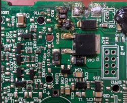 Uszkodzona płytka PCB z przypalonymi elementami elektronicznymi w okolicy tranzystora.
