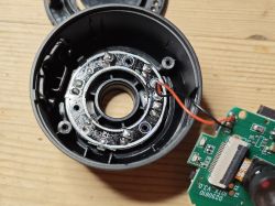 Inside view of disassembled camera with circuit board Disassembled camera showing internal housing and circuit board