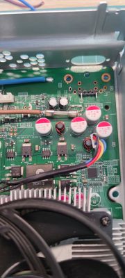 Zbliżenie na płytę drukowaną z komponentami elektronicznymi i kablami.