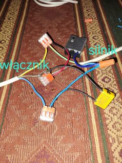 Zbliżenie na przewody elektryczne połączone z wtykami, oznaczone jako włącznik i silnik.