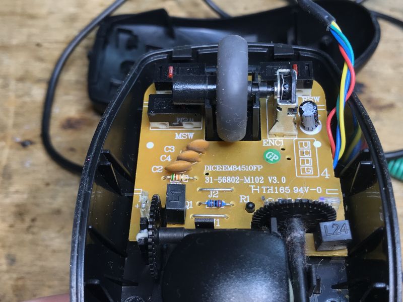Inside of a Computer Mouse with PCB Inside view of an old computer mouse with visible PCB and components.