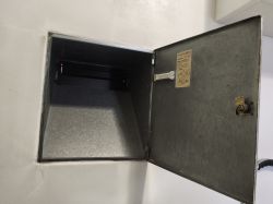 Open recessed metal box with hinged door and latch