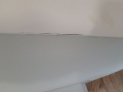 Zbliżenie na linię styku ściany i listwy; widoczny wąski aluminiowy narożnik na krawędzi.