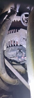 Alternator w samochodzie Renault Scenic II, widok od spodu z przewodami i częściami mechanicznymi na pierwszym planie.