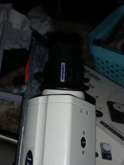 Biała kamera CCTV z zamontowanym obiektywem Computar 3,5–8 mm na metalowym uchwycie