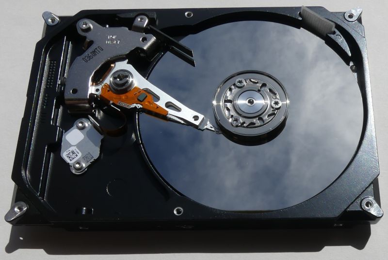 Interior of a hard drive with visible platter and read/write arm.