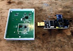 M5-3C-80W PCB and CH341 Programmer M5-3C-80W wall switch PCB and USB CH341 programmer on a wooden workbench.