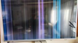 Ekran telewizora z kolorowymi pionowymi pasami zakłóceń.