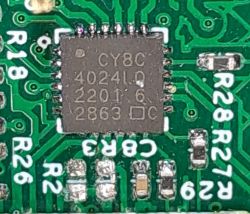 Image of Infineon CY8C4024LQ microcontroller and SMD resistors on a printed circuit board.