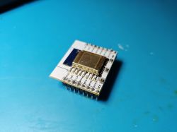C-8133U module attached to ESP-12E board on a blue table background.