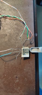 Electronic setup with a microcontroller connected to several wires on a dark surface.