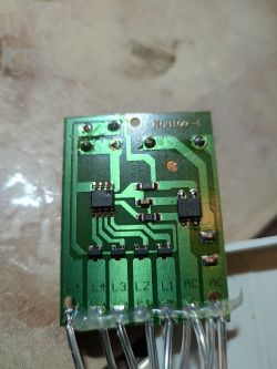 Zbliżenie na zieloną płytkę PCB z widocznymi ścieżkami i elementami elektronicznymi